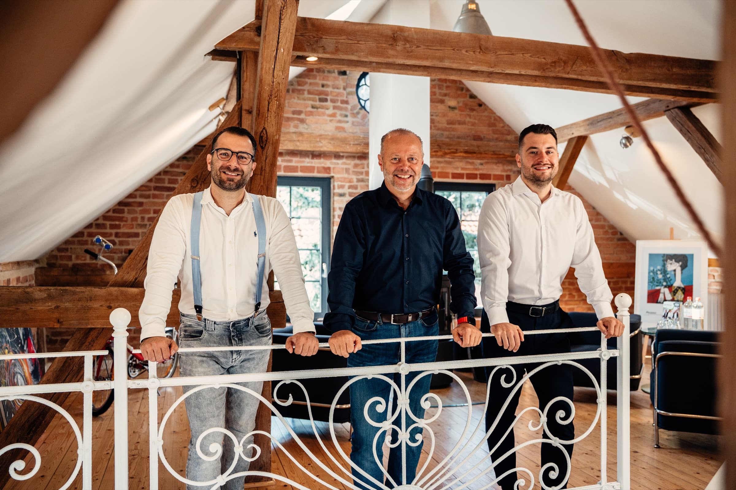 Das dreiköpfige Team von du Chesne Immobilien in einem hellen Dachgeschoss